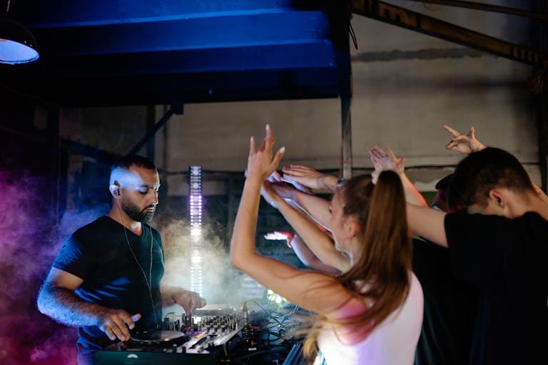 A dynamic DJ set in a vibrant nightclub with an enthusiastic crowd and atmospheric lighting.